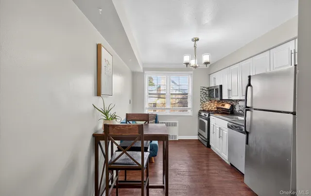 a kitchen with stainless steel appliances a dining table chairs stove and refrigerator