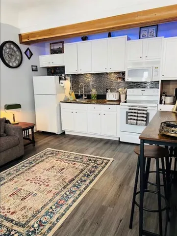 a kitchen with a refrigerator and a stove top oven