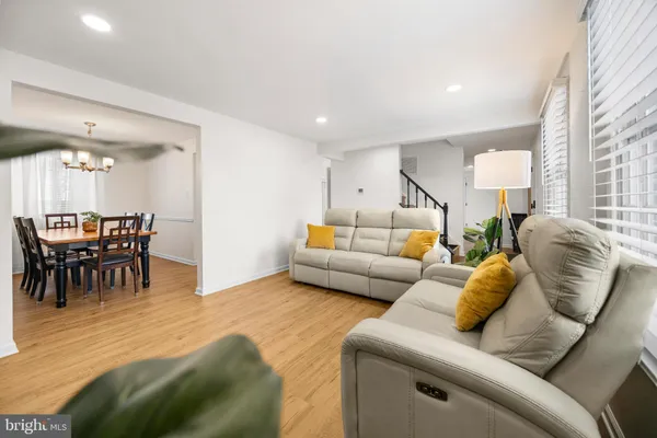 a living room with furniture and a dining table with kitchen view
