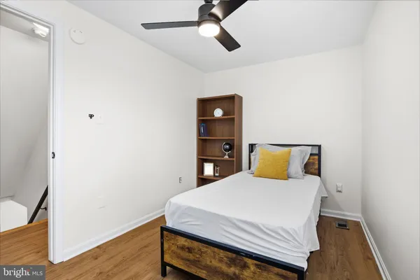 a bedroom with a bed and wooden floor