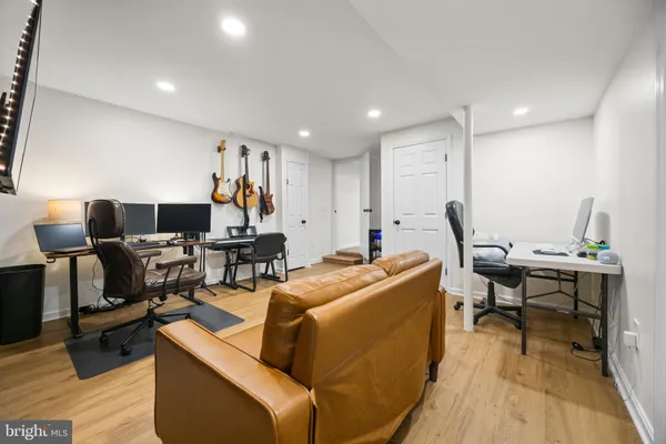 a living room with furniture flat screen tv and wooden floor