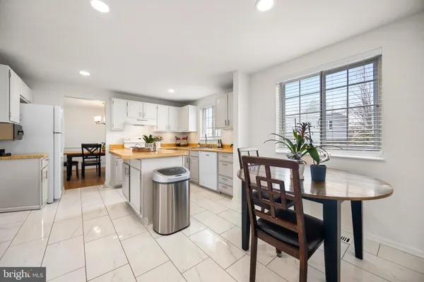 a kitchen with a dining table chairs and refrigerator