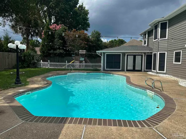 a view of a house with swimming pool and sitting area