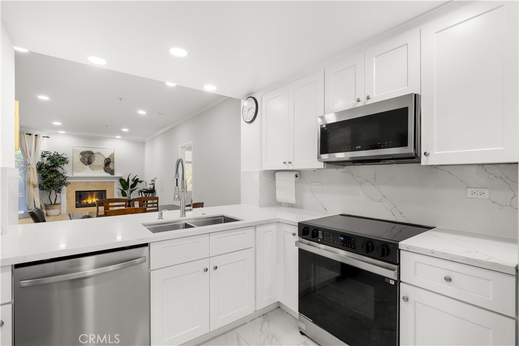 2253 Martin, Unit 106 Irvine, CA 92612 - Photo 9 of 19 a kitchen with a sink stainless steel appliances and white cabinets