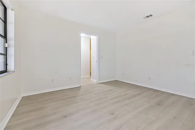 a view of an empty room with wooden floor