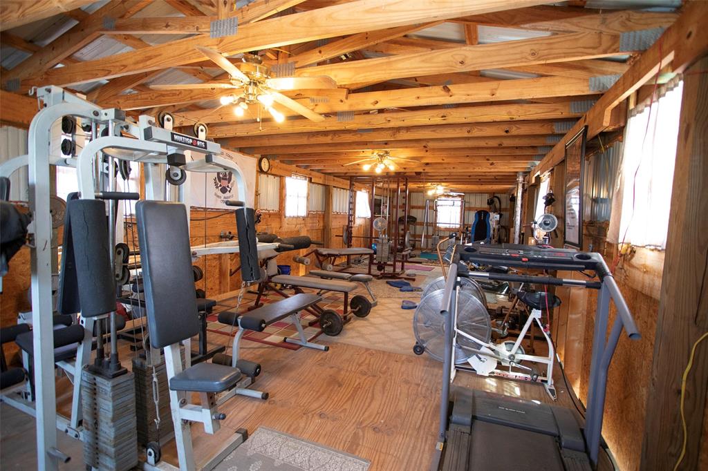 7060 Hells Gate Loop Strawn, TX 76475 - Photo 30 of 40 Workout area with wood finished floors, ceiling fan, and lofted ceiling