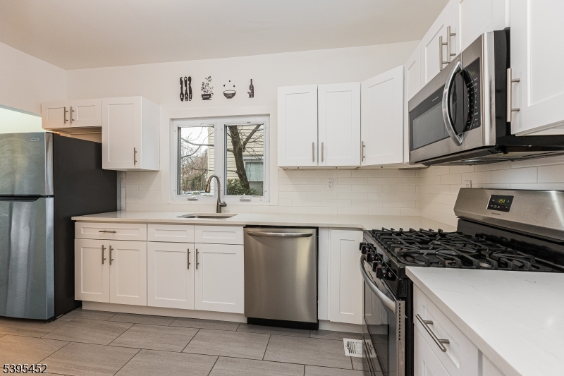 112 Pompton Avenue, Unit 1 Verona, NJ 07044 - Photo 13 of 25 a kitchen with stainless steel appliances granite countertop a sink stove and refrigerator