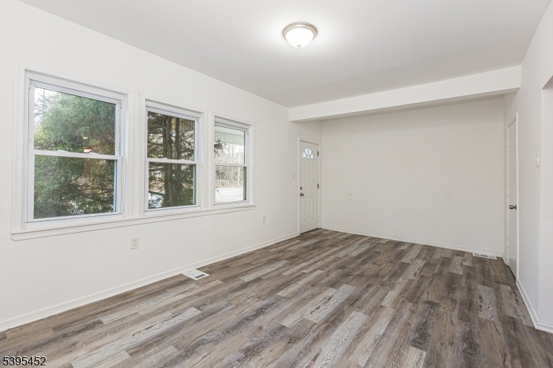 112 Pompton Avenue, Unit 1 Verona, NJ 07044 - Photo 2 of 25 an empty room with wooden floor and windows