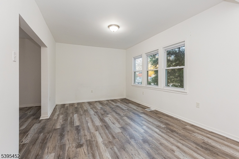 112 Pompton Avenue, Unit 1 Verona, NJ 07044 - Photo 3 of 25 an empty room with wooden floor and windows