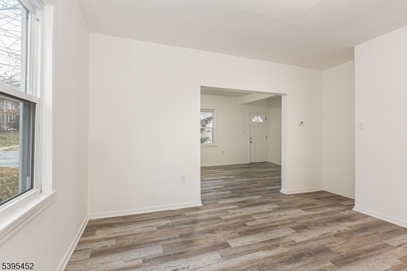 112 Pompton Avenue, Unit 1 Verona, NJ 07044 - Photo 6 of 25 an empty room with wooden floor and windows