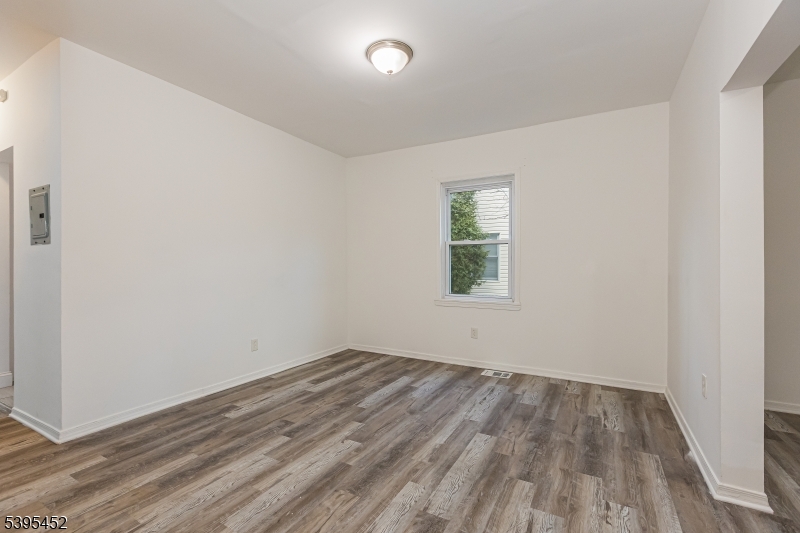 112 Pompton Avenue, Unit 1 Verona, NJ 07044 - Photo 7 of 25 an empty room with wooden floor and windows