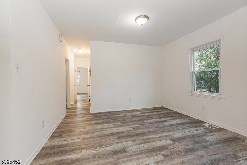 112 Pompton Avenue, Unit 1 Verona, NJ 07044 - Photo 8 of 25 a view of an empty room with wooden floor and a window