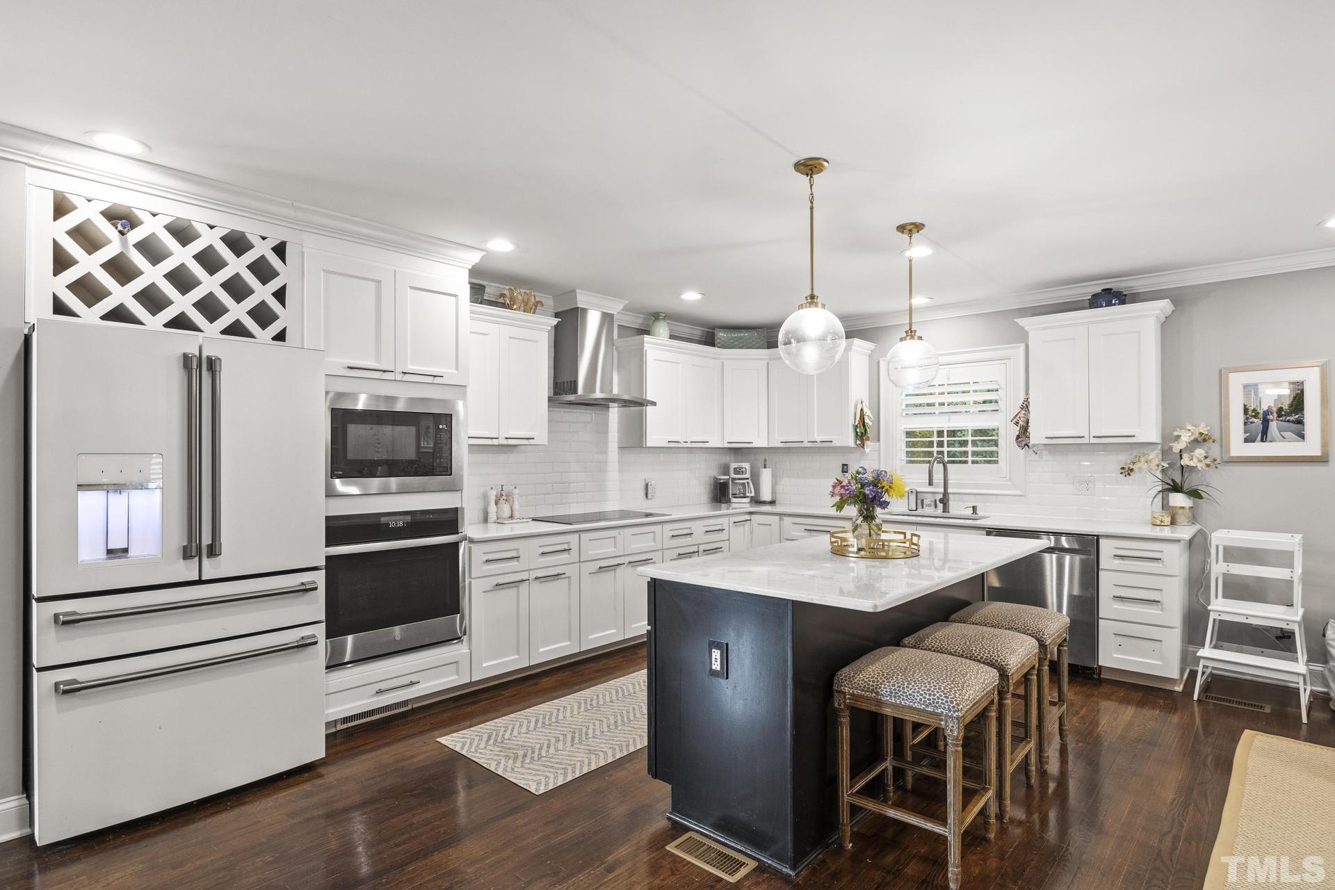 4816 Radcliff Road Raleigh, NC 27609 - Photo 11 of 52 a kitchen with white cabinets and stainless steel appliances