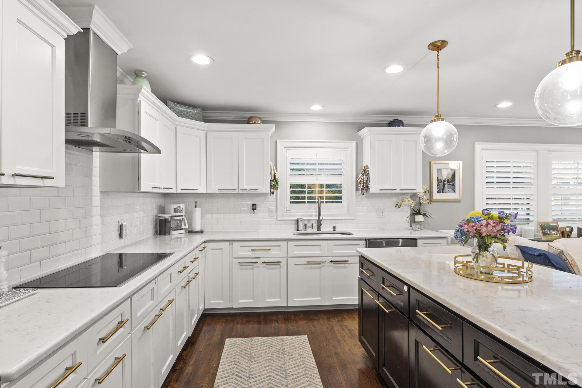 4816 Radcliff Road Raleigh, NC 27609 - Photo 12 of 52 a kitchen with kitchen island granite countertop a sink a counter space appliances and cabinets