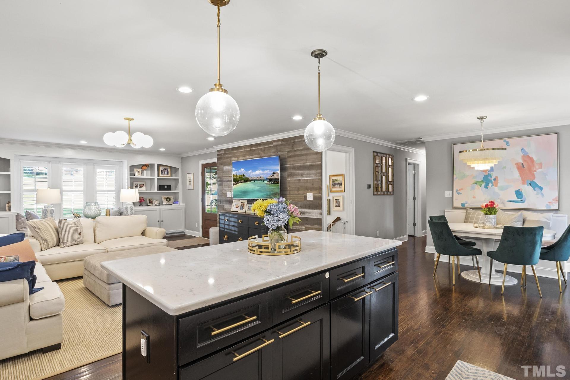 4816 Radcliff Road Raleigh, NC 27609 - Photo 13 of 52 a view of a dining room and livingroom with furniture wooden floor a chandelier