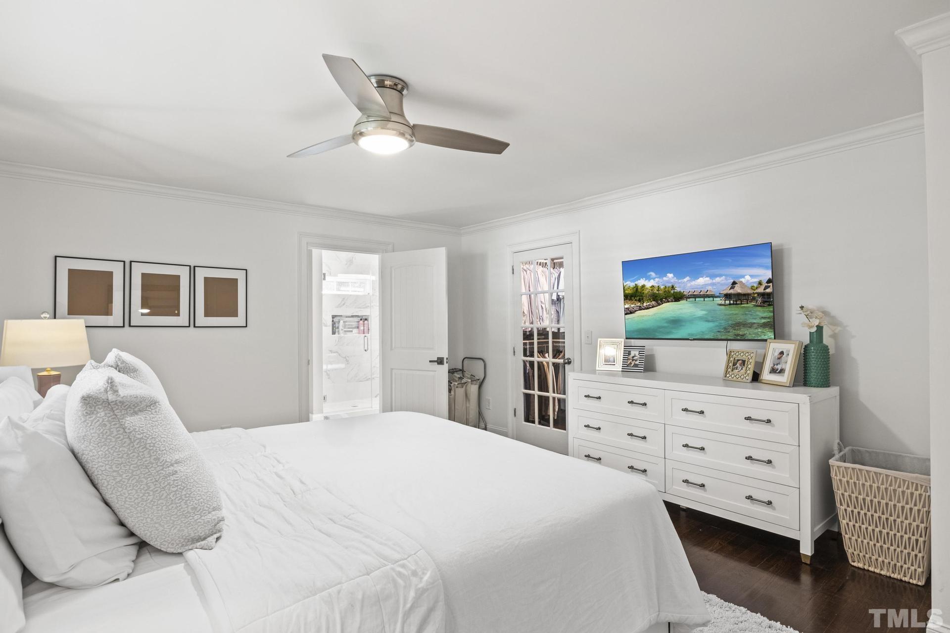 4816 Radcliff Road Raleigh, NC 27609 - Photo 20 of 52 a bedroom with a bed and a flat tv screen on dresser