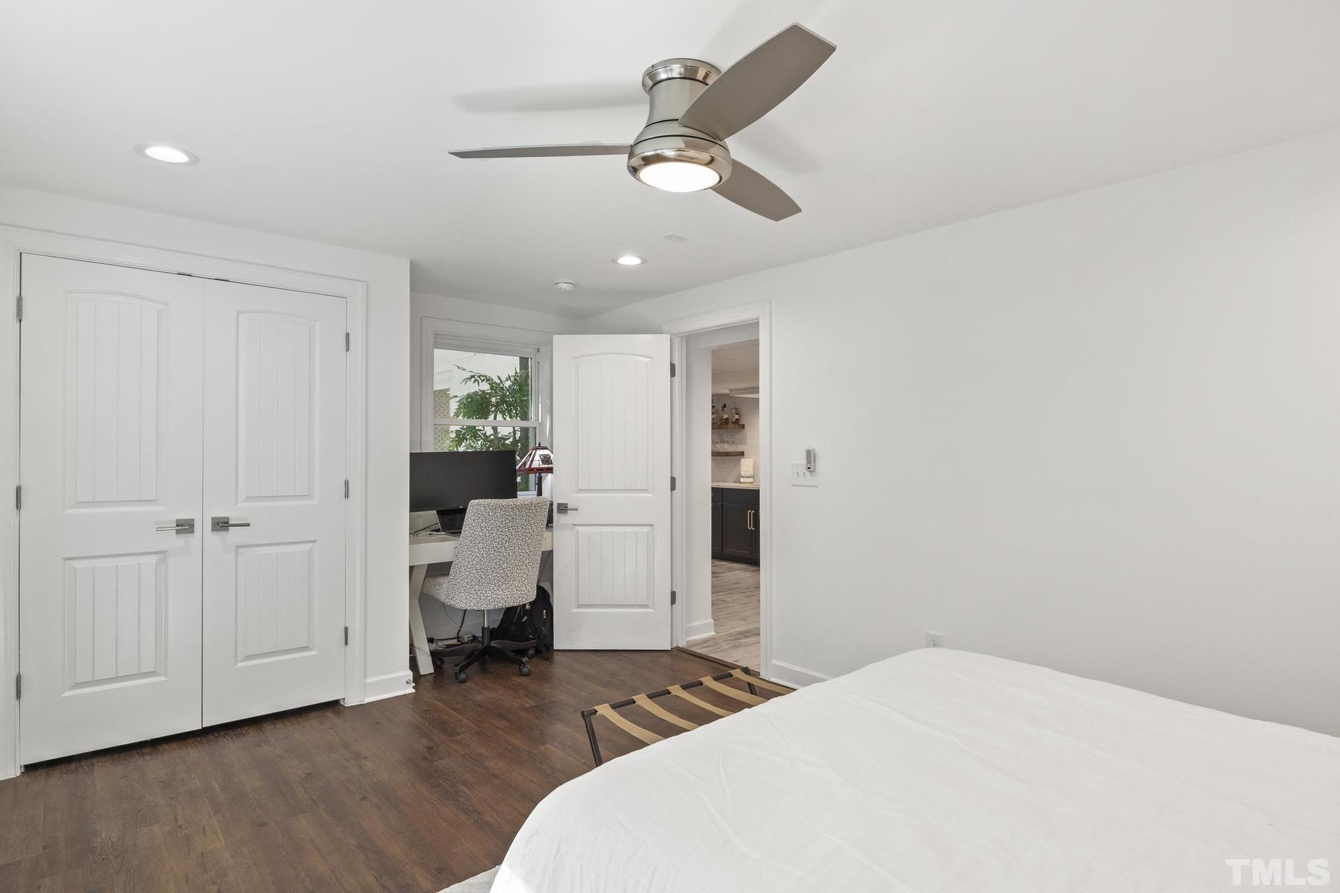 4816 Radcliff Road Raleigh, NC 27609 - Photo 40 of 52 a bedroom with a bed and a chandelier fan