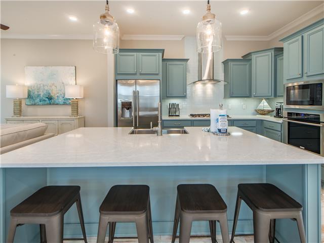 138 East E Pine, Unit A Inlet Beach, FL 32461 - Photo 12 of 48 a kitchen with a table chairs refrigerator and microwave