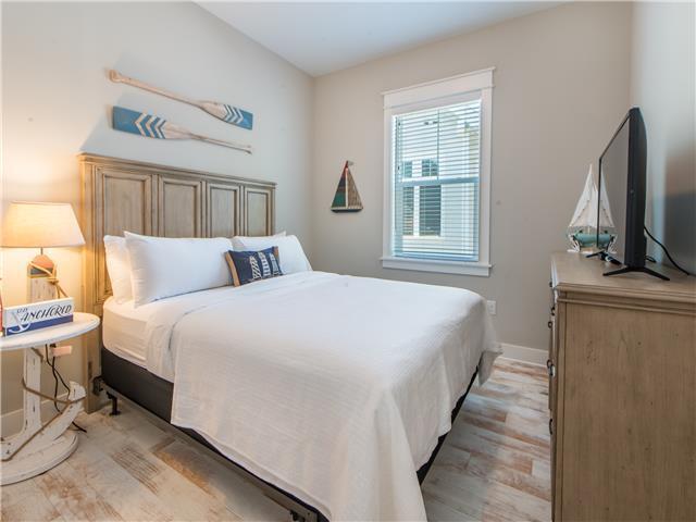 138 East E Pine, Unit A Inlet Beach, FL 32461 - Photo 7 of 48 a bedroom with a bed and a flat tv screen on a dresser