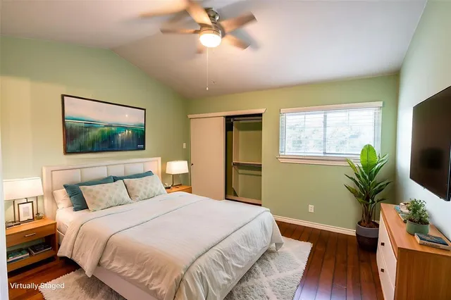 a bedroom with a bed and a flat tv screen on dresser