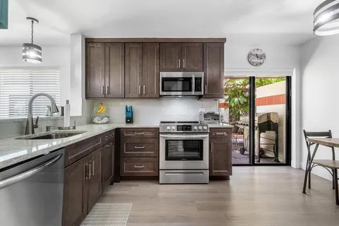 a kitchen with stainless steel appliances granite countertop a stove a sink and a microwave