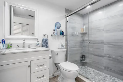 a bathroom with a sink toilet vanity and shower