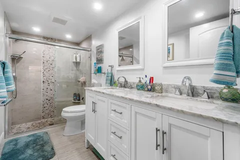 a bathroom with a granite countertop sink toilet and shower