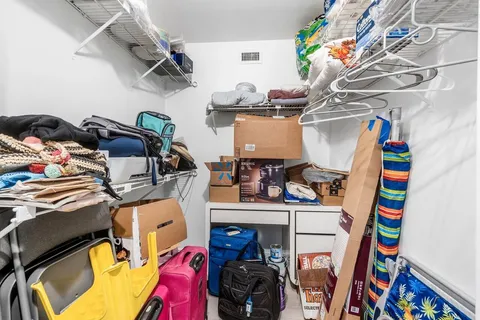 a view of walk in closet with clothes and shoes
