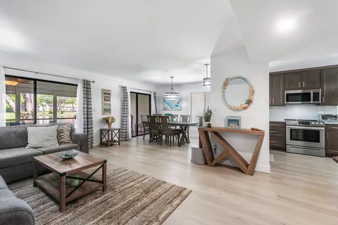 a living room with furniture a flat screen tv and a large window