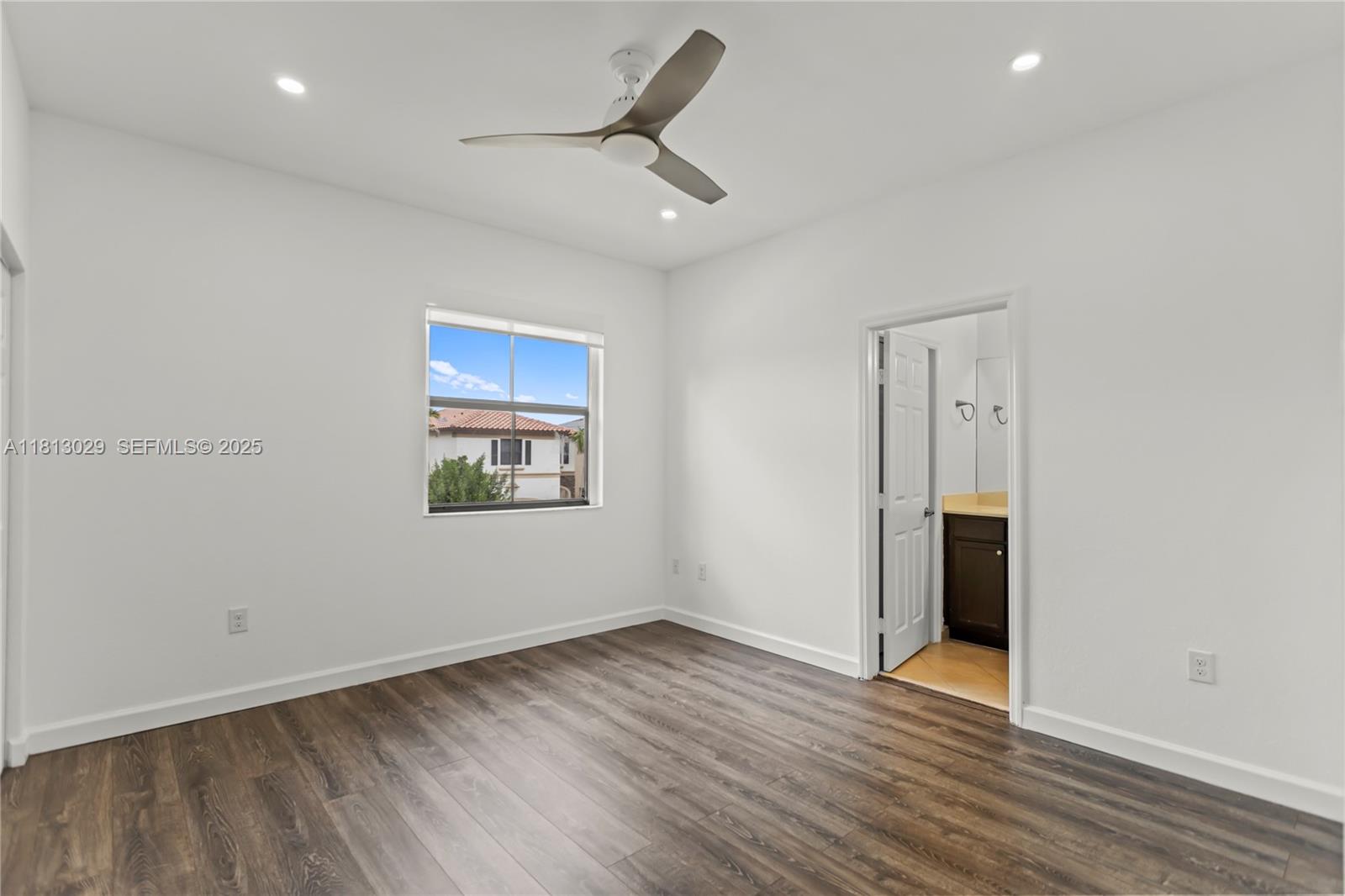 3502 West 86th Terrace Hialeah, FL 33018 - Photo 31 of 68 an empty room with wooden floor and windows