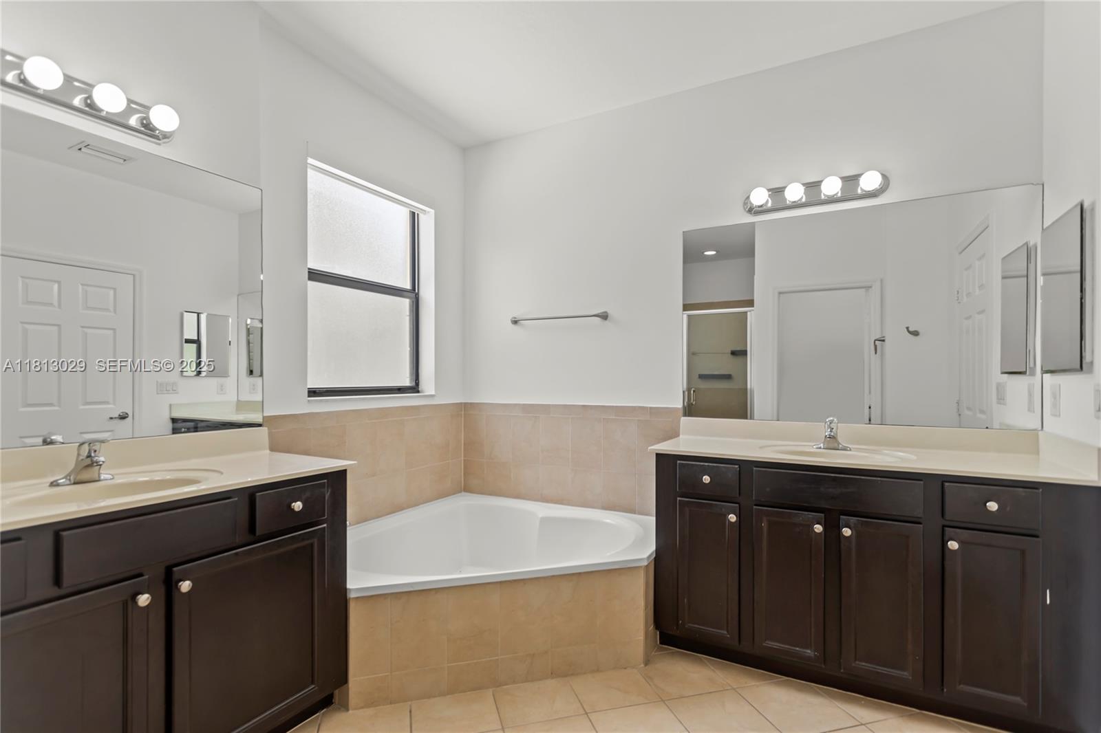 3502 West 86th Terrace Hialeah, FL 33018 - Photo 52 of 68 a spacious bathroom with a tub double sink and mirror