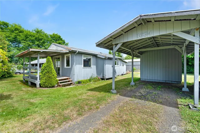 a view of a backyard with plants and a barbeque