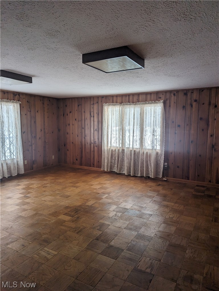 276 Paradise Road Painesville, OH 44077 - Photo 16 of 31 Empty room with a textured ceiling and wooden walls