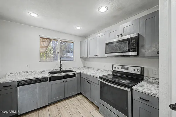 a kitchen with stainless steel appliances granite countertop a sink stove a microwave and cabinets