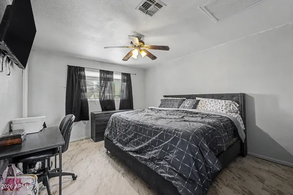 a bedroom with bed and wooden floor