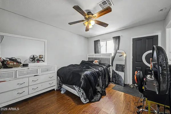a bedroom with a bed and wooden floor