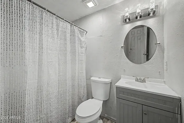 a bathroom with a sink a toilet and a mirror