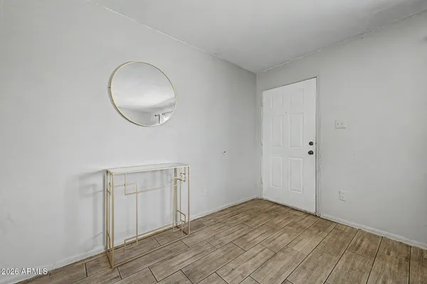 a view of a room with wooden floor and white walls