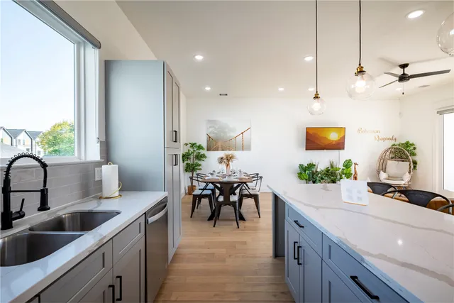 a kitchen with kitchen island granite countertop a sink a counter top space and living room view