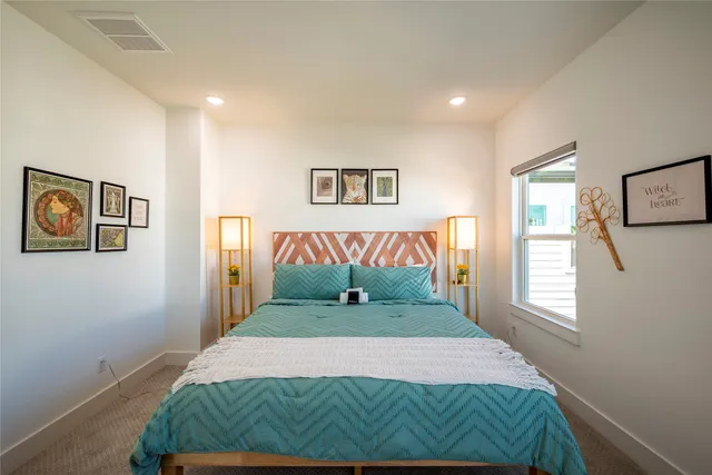 a bedroom with a bed and painting on the wall