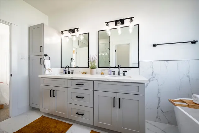 a bathroom with a tub sink and mirror