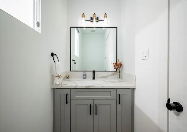 a bathroom with a sink a toilet a mirror and shower