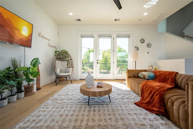a living room with furniture a window and a potted plant