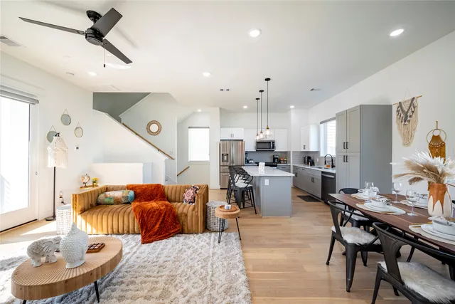 a living room with furniture kitchen view and a wooden floor
