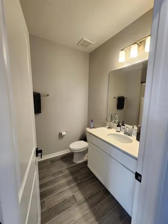 a bathroom with a sink and mirror with toilet