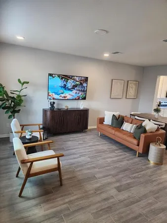 a living room with furniture a potted plant and paintings on the wall