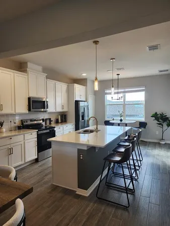 a kitchen with kitchen island granite countertop wooden floors and white appliances