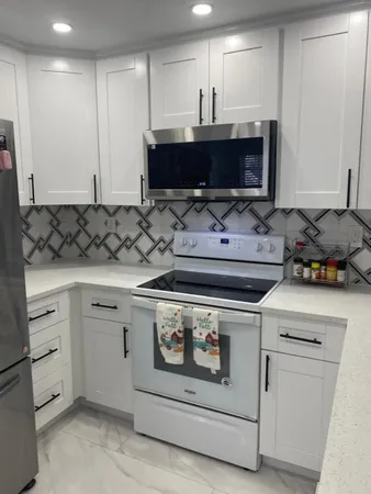 a kitchen with stainless steel appliances granite countertop a stove a sink and a microwave