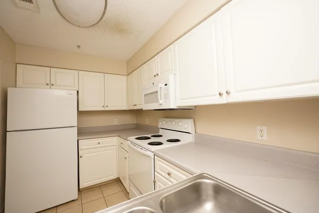 a kitchen with cabinets and white appliances