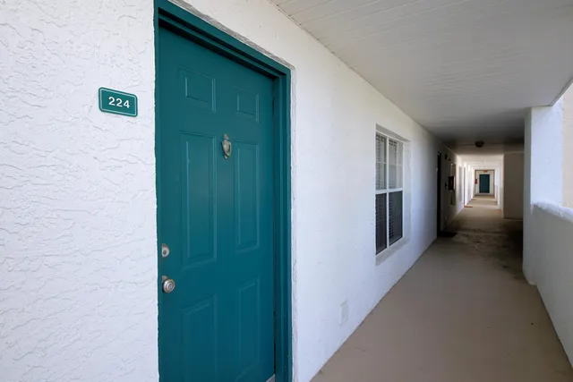 a view of a hallway with wooden floor and windows